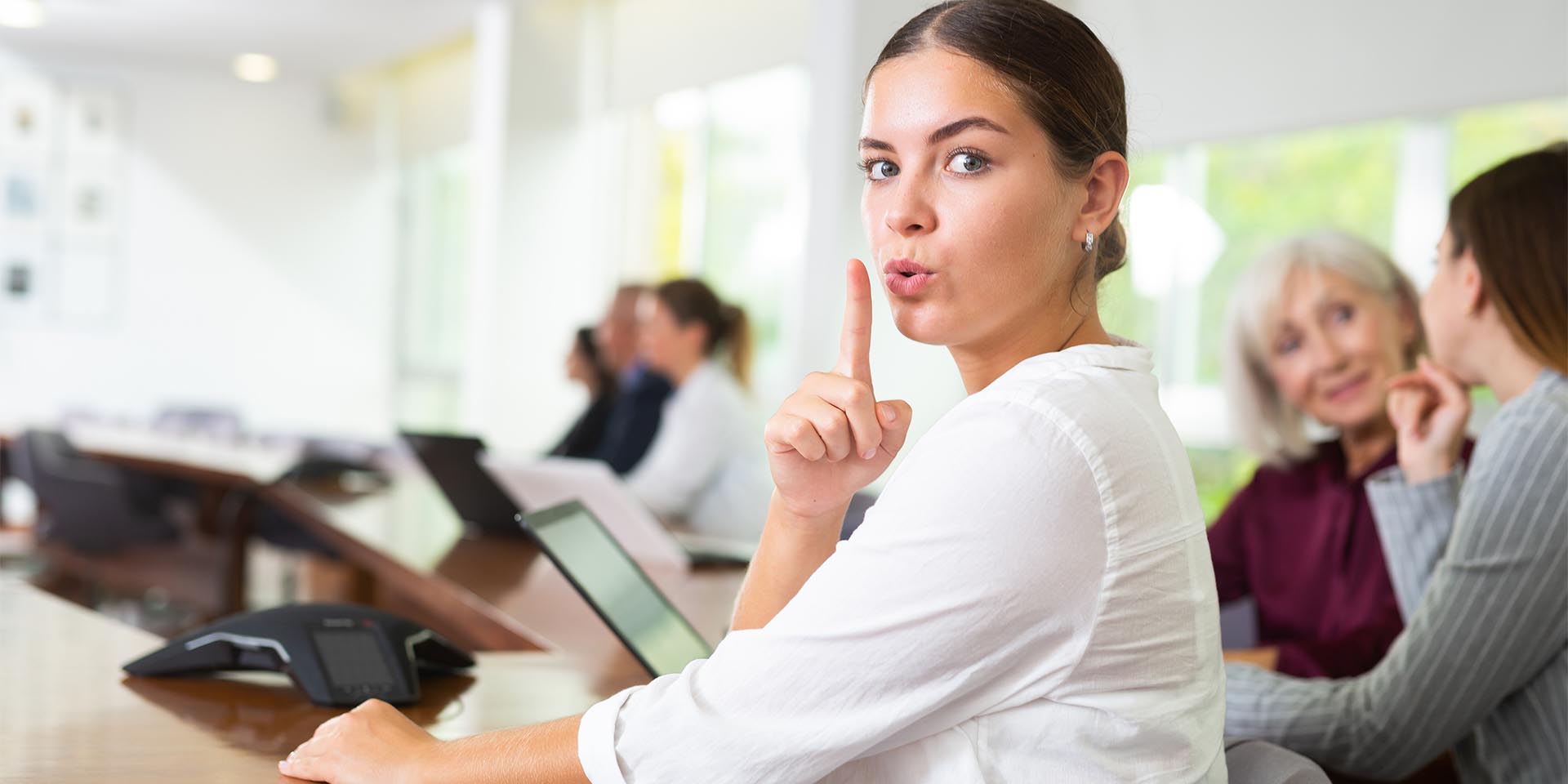 Eine Mitarbeiterin fungiert als Hinweisgeberin in ihrem Unternehmen. Sie hält sich einen Finger vor den Mund. © Adobe Stock, JackF