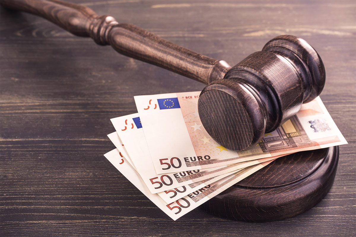 Holzhammer auf mehreren 50-Euro-Scheinen als Symbol für Geldstrafen bei Verstößen im Arbeitsschutz. © Adobe Stock, Yingko