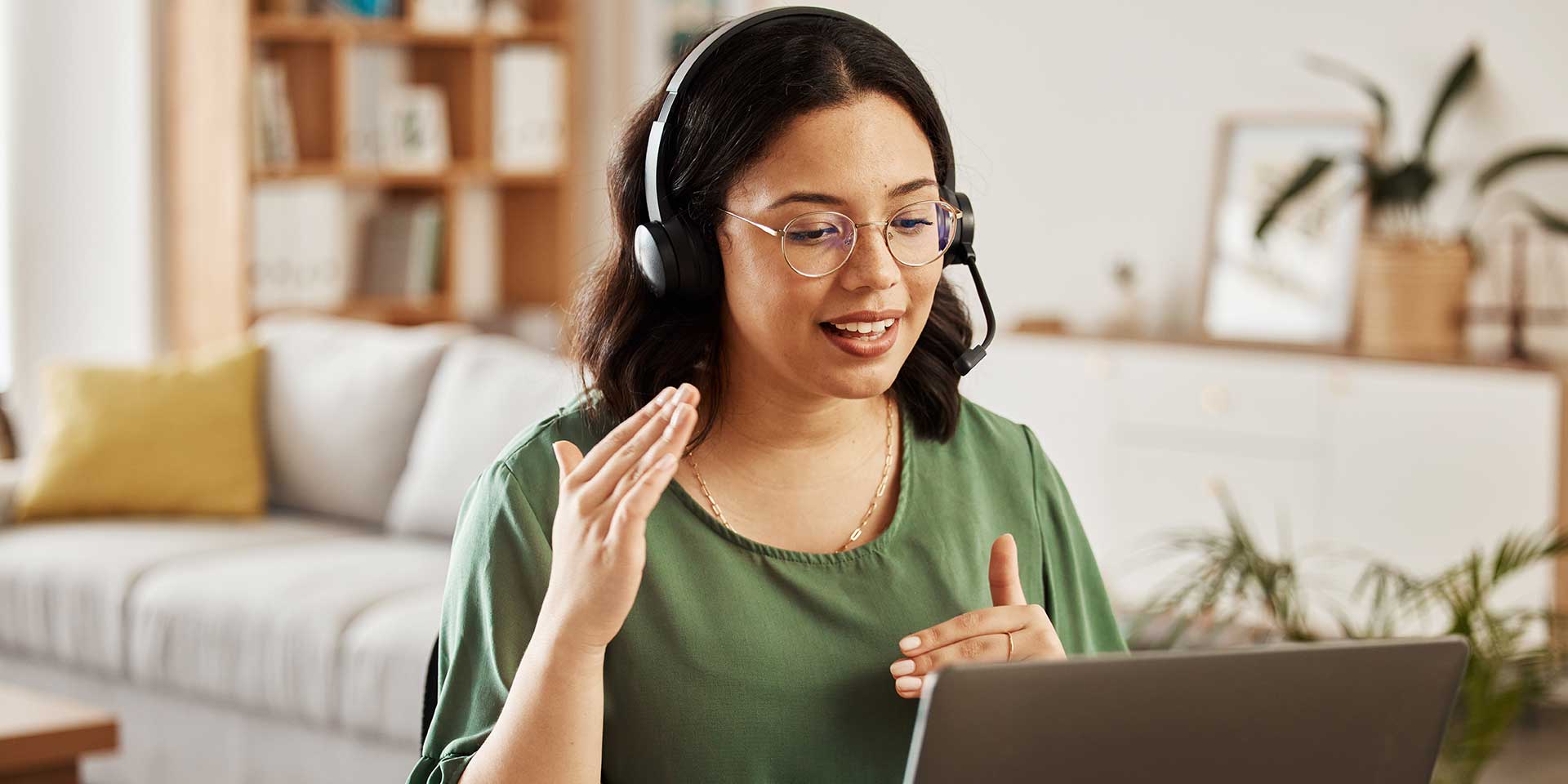 Mitarbeiterin arbeitet im Homeoffice und spricht in einem Online-Meeting.